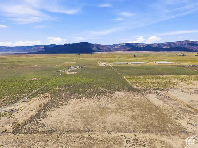 Expansive rural property featuring varied vegetation and distant mountain ranges