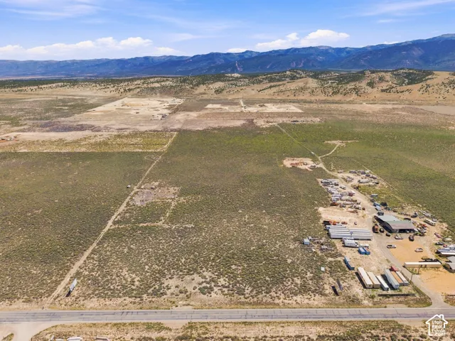 Expansive undeveloped land with visible utility lines and mountain backdrop