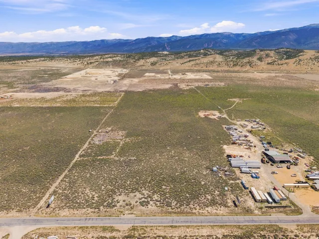 Expansive undeveloped land with visible utility lines and mountain backdrop