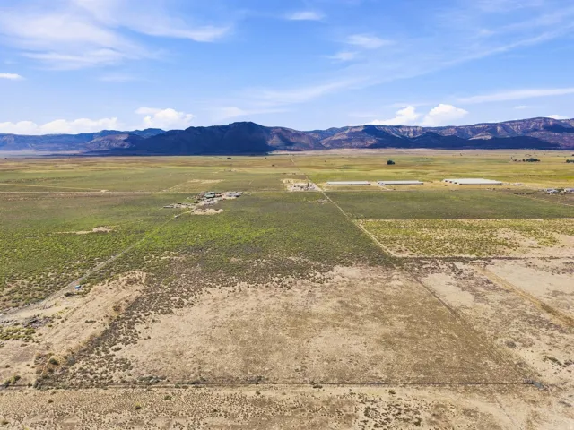 Expansive rural property featuring varied vegetation and distant mountain ranges