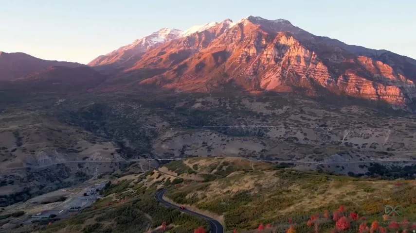 Expansive mountain scenery featuring snow-capped peaks and winding roads