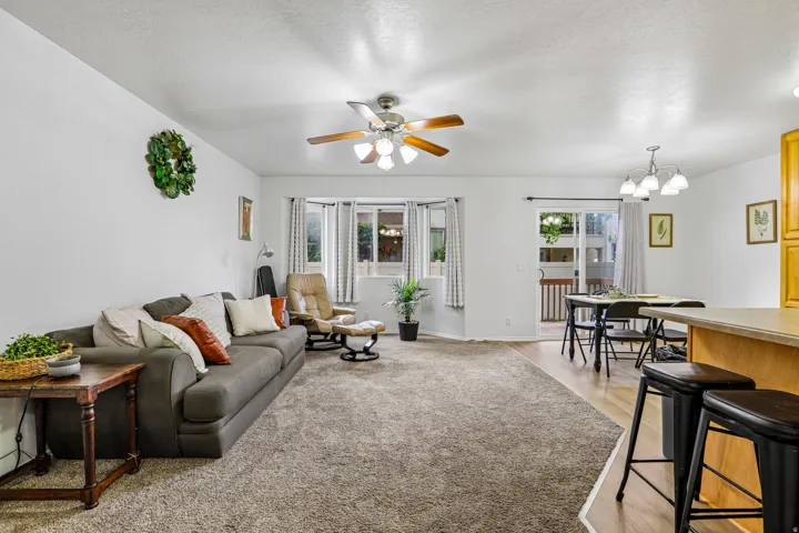 Open concept living area with carpeting and wood-finish flooring