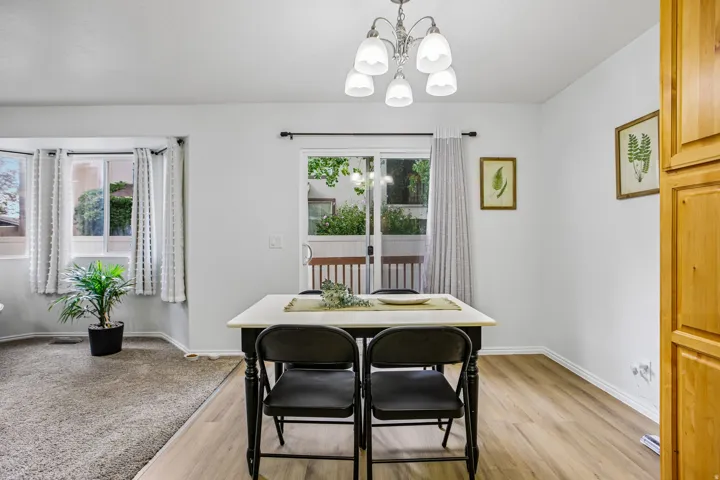 Recessed bay window, wood-finish flooring, sliding glass door, overhead chandelier, and built-in wood cabinetry