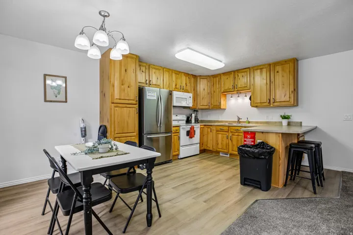 Wood-finish flooring throughout, complemented by wood cabinetry and stainless steel appliances