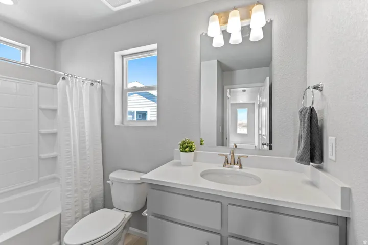 Vanity with an integrated sink, brushed nickel faucet, and a large mirror