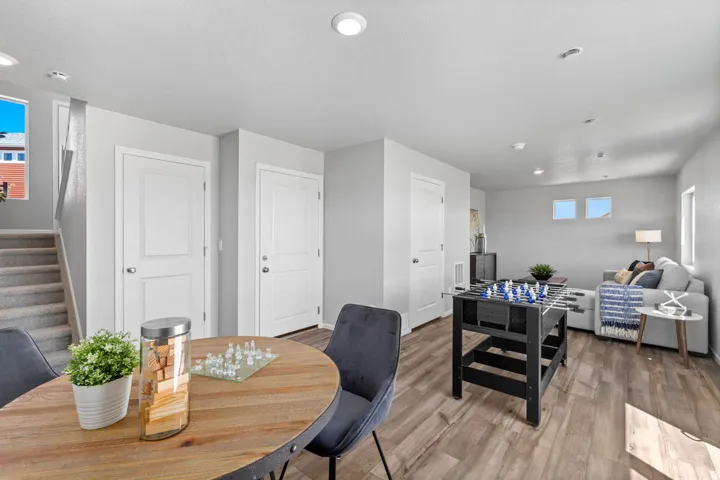 Recessed lighting, wood-finish flooring, white paneled doors, and a carpeted staircase