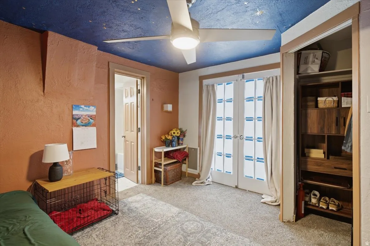 Primary bedroom with the small walk-in closet to the right, French doors to the patio in the center, and bathroom to the left.