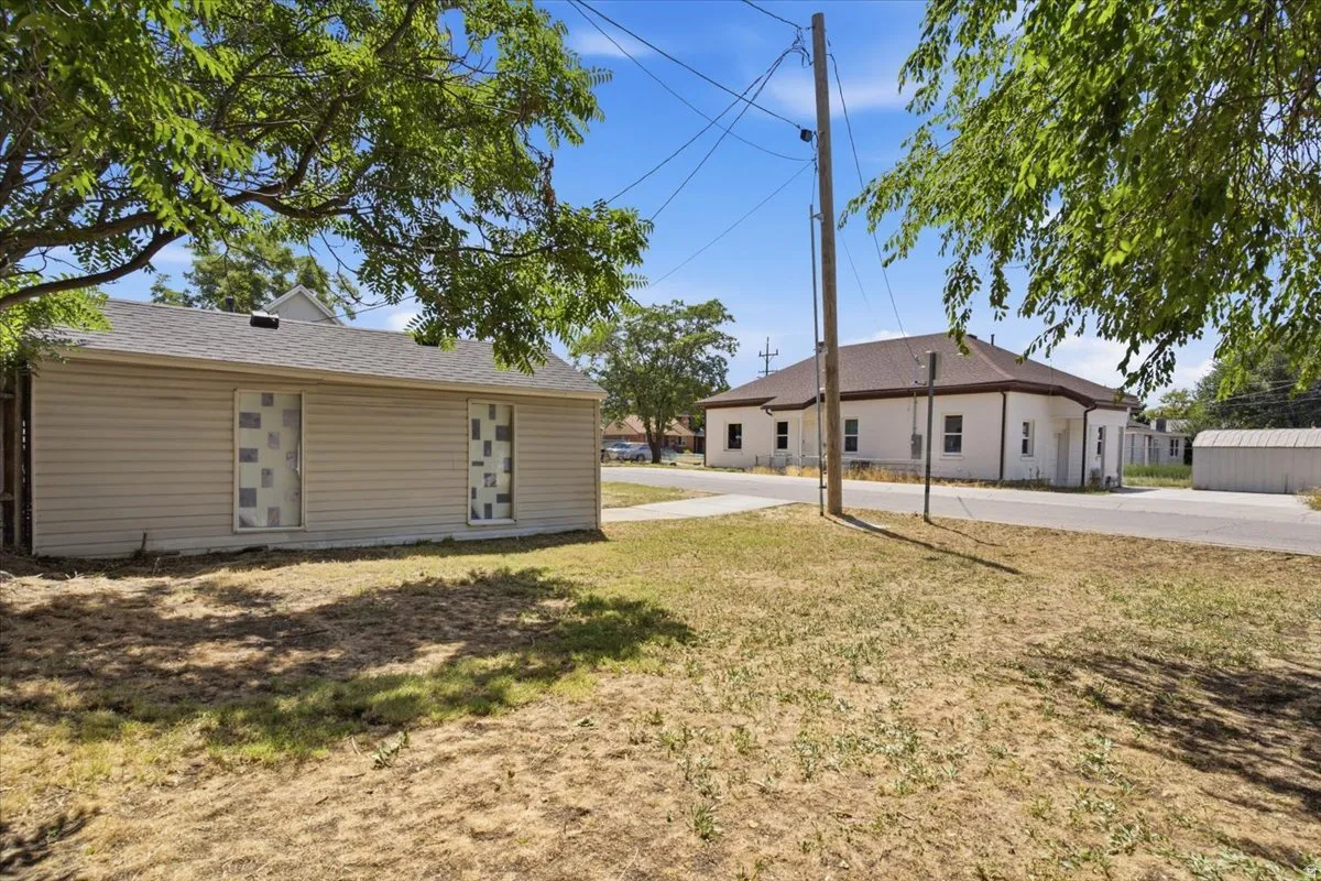 Side yard which is big enough for an RV. May be possible for a tiny home there. Shows the back side of the accessory building.