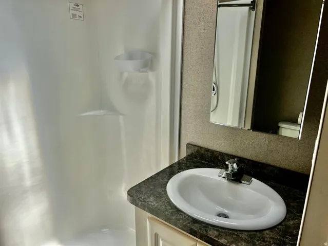 White fiberglass shower enclosure with built-in shelving
