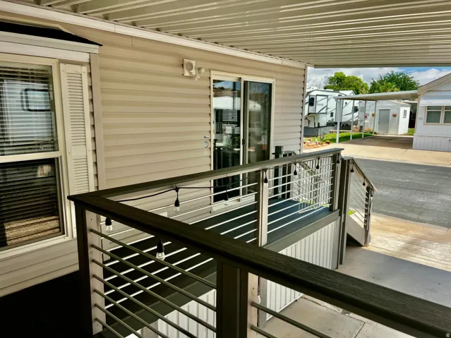 Covered deck with composite decking and horizontal railing, sliding glass door, and vinyl siding
