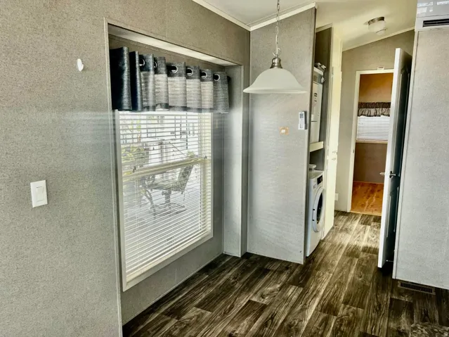 Wood-finish flooring, built-in laundry center, overhead pendant lighting, and neutral wall finishes
