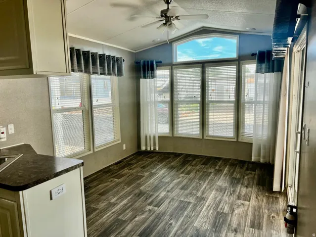 Expansive living area featuring wood-finish flooring and a ceiling fan