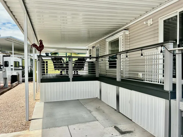 Covered patio with durable composite decking, sleek metal railings, and light-toned siding