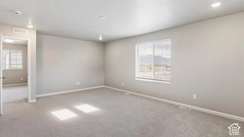 Neutral tone wall finishes, recessed lighting, carpet flooring, window with blinds, and mountain scenery