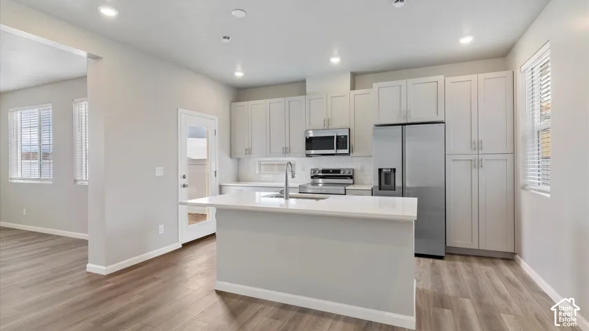 Kitchen with wood-finish flooring, recessed lighting, and a center island