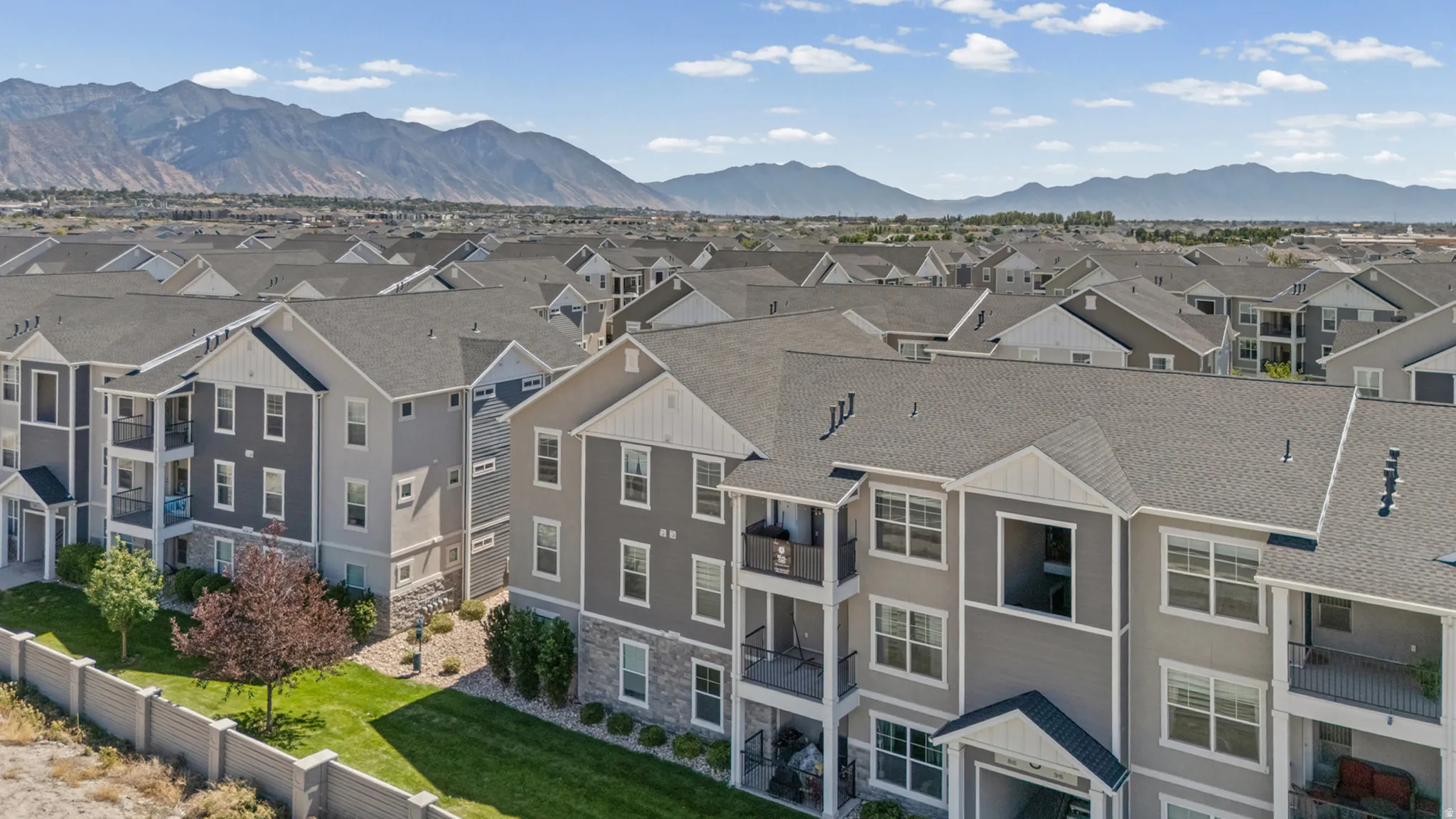 Multi-story structures with balconies and individual entrances, featuring varied siding materials and pitched roofs