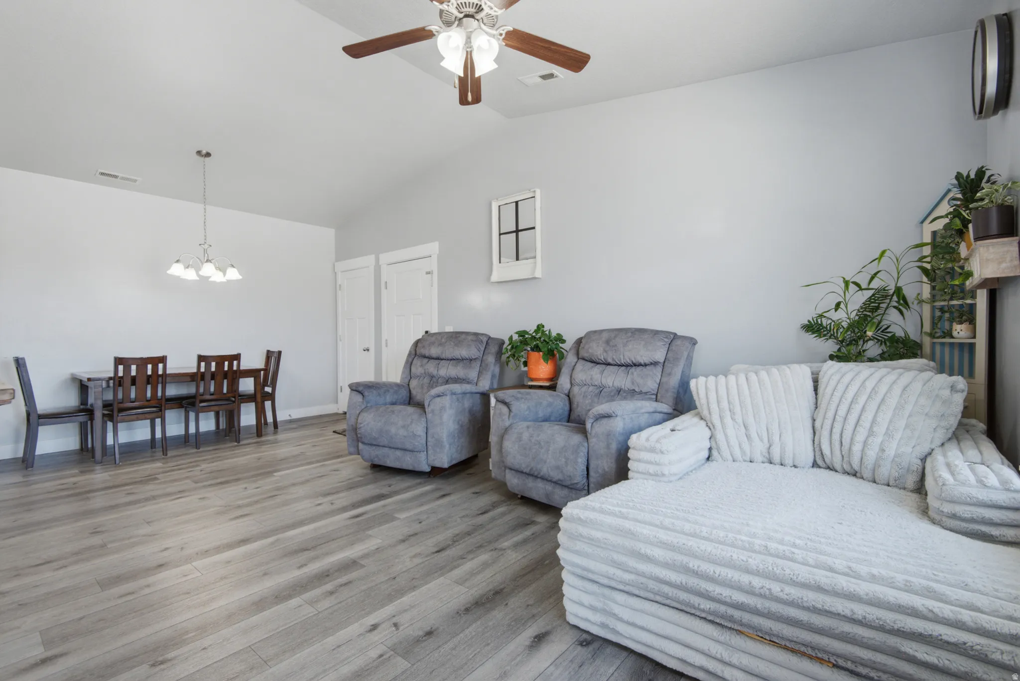 Wood-finish flooring throughout, vaulted ceiling with a ceiling fan, and recessed lighting