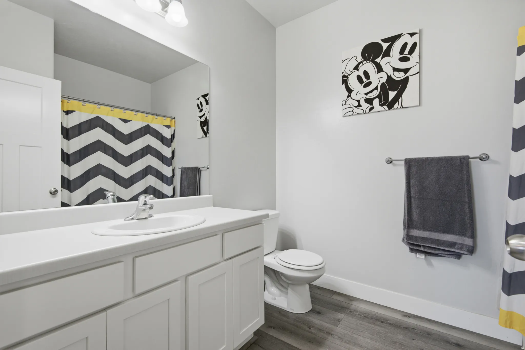 White vanity with shaker-style cabinetry, an integrated sink, and a chrome faucet