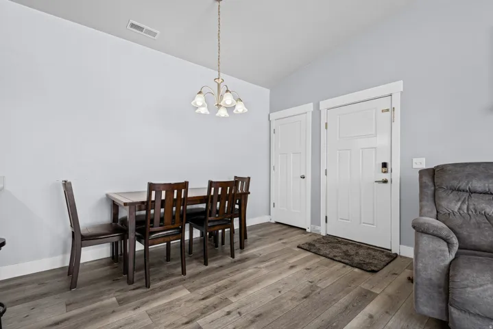 Wood-finish flooring, vaulted ceiling, and classic overhead lighting