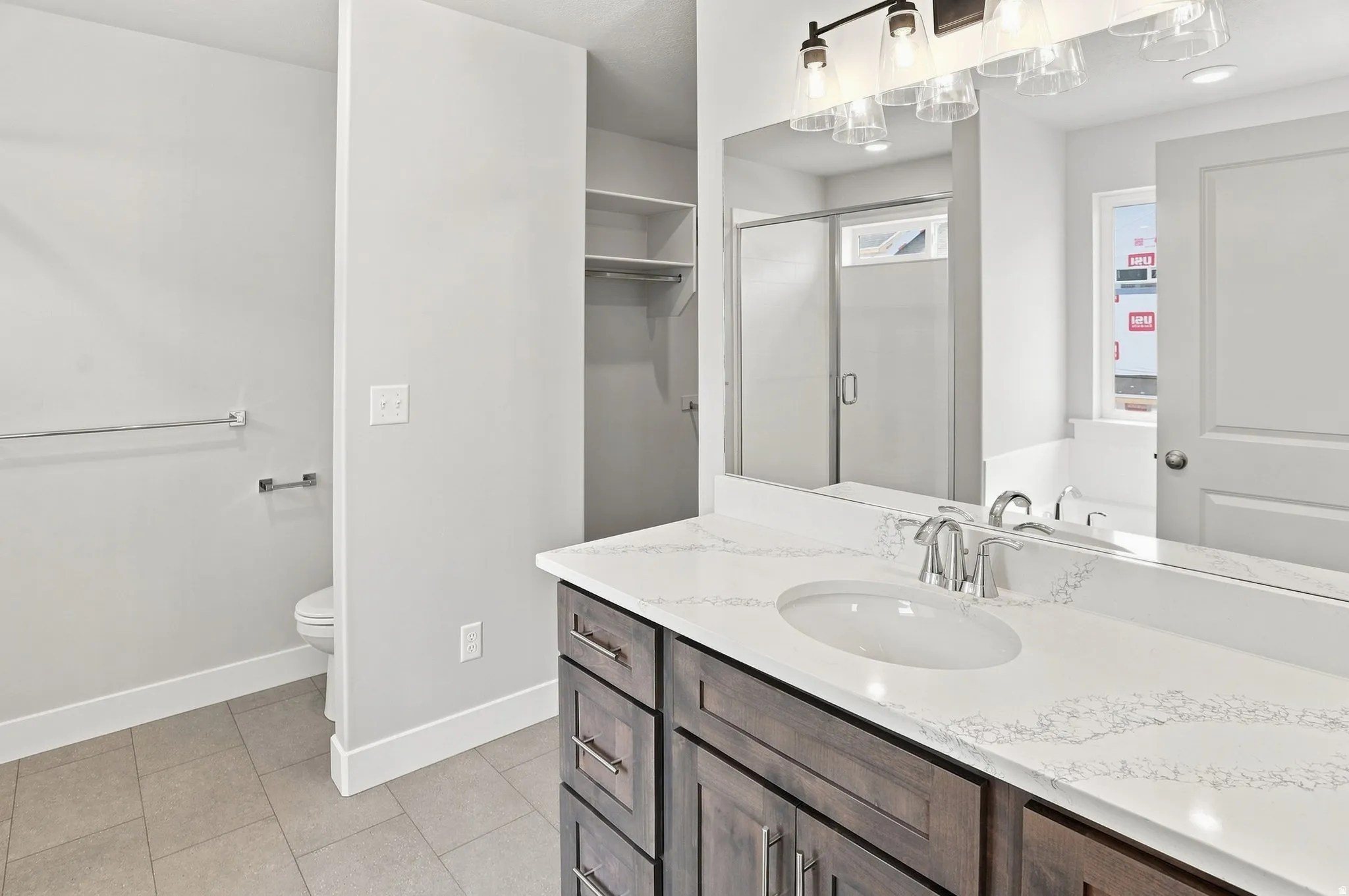 Wood-finish vanity with an undermount sink, a white countertop, and a large mirror