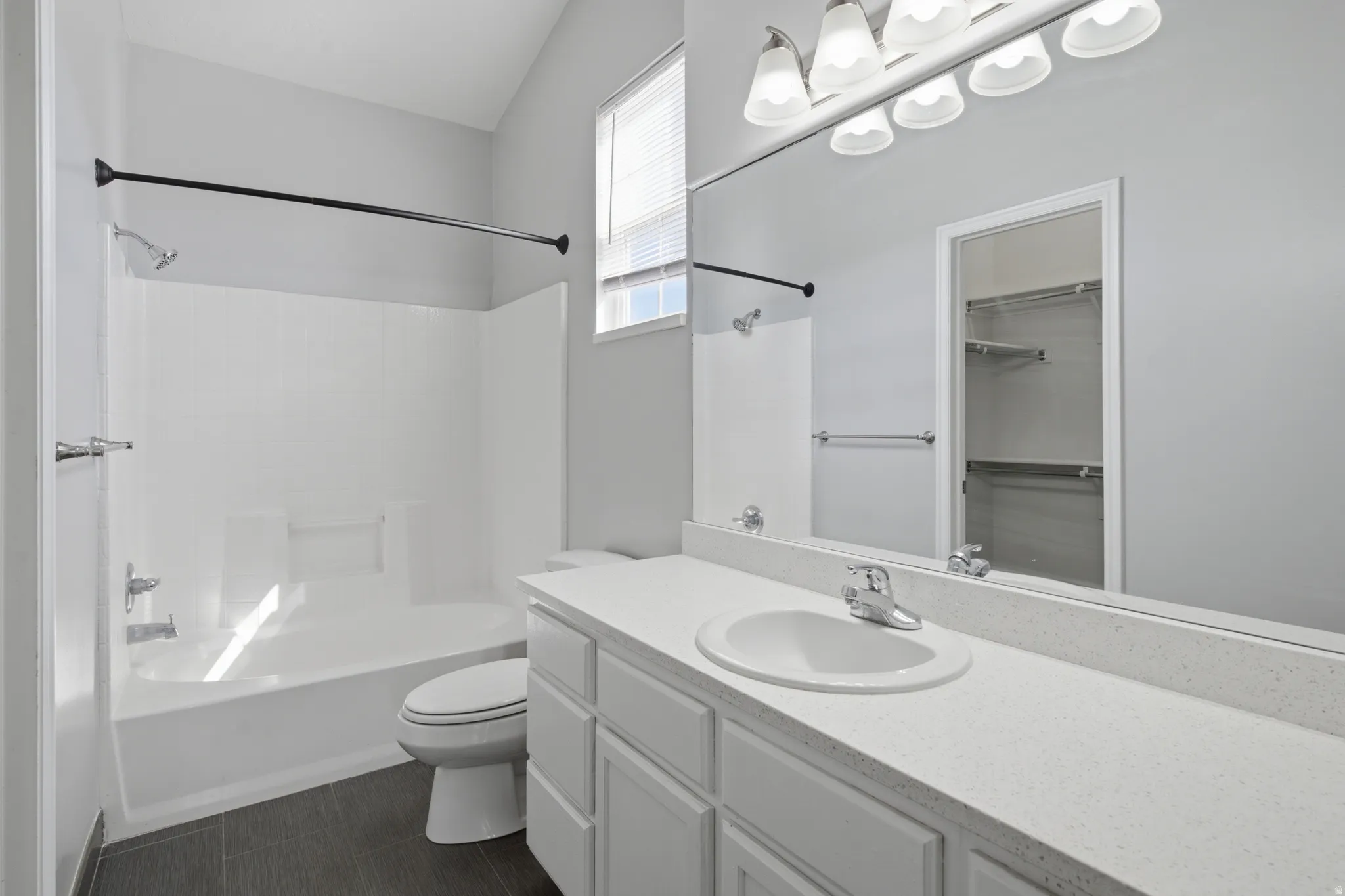 White vanity with a large countertop, integrated sink, and chrome faucet