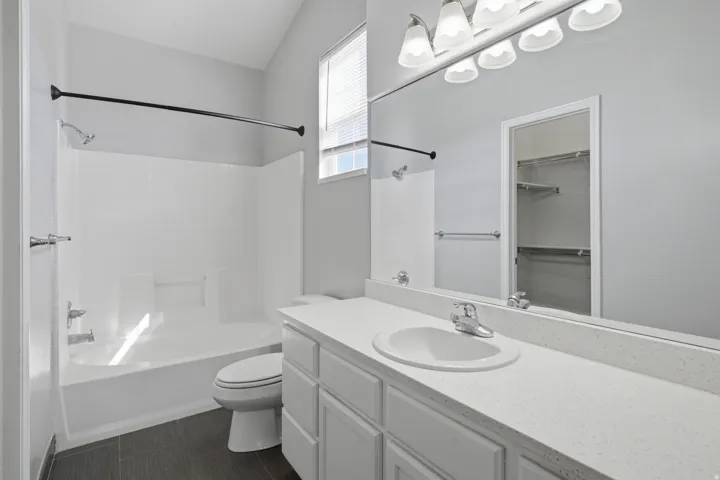 White vanity with a large countertop, integrated sink, and chrome faucet