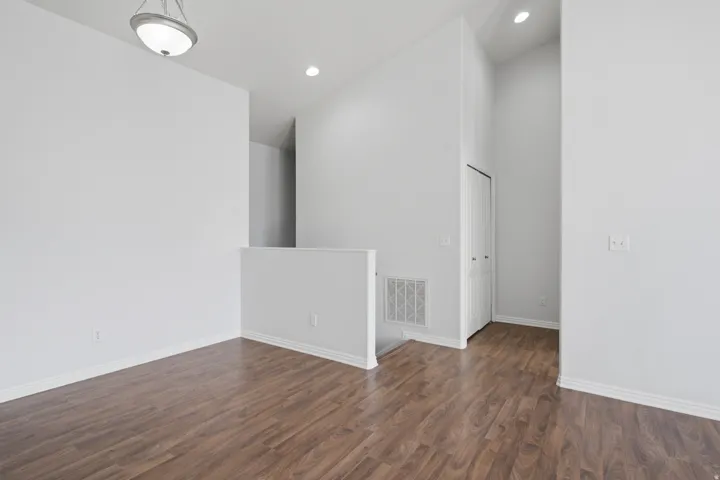 Wood-finish flooring, vaulted ceiling, and recessed lighting