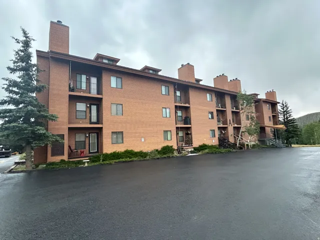 Multi-story building featuring balconies, exposed brick, and wood-finish siding