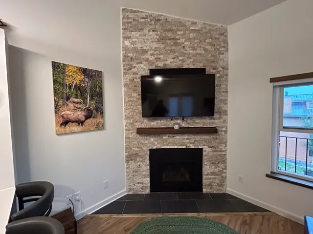 Built-in fireplace featuring a black firebox and a stone surround, complemented by a wood-finish mantel