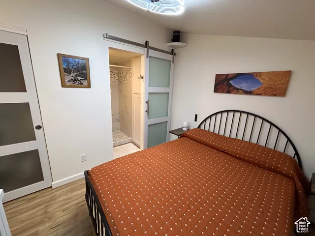 Wood-finish flooring, white walls, and a sliding barn door with frosted panels