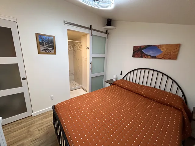 Wood-finish flooring, white walls, and a sliding barn door with frosted panels