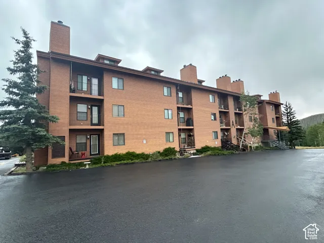 Multi-story building featuring balconies, exposed brick, and wood-finish siding