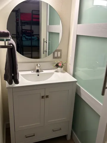 White vanity with an integrated sink and brushed nickel faucet