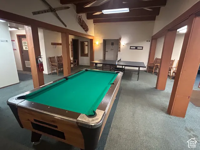 Recreational room featuring a pool table, two ping pong tables, and exposed wood beams