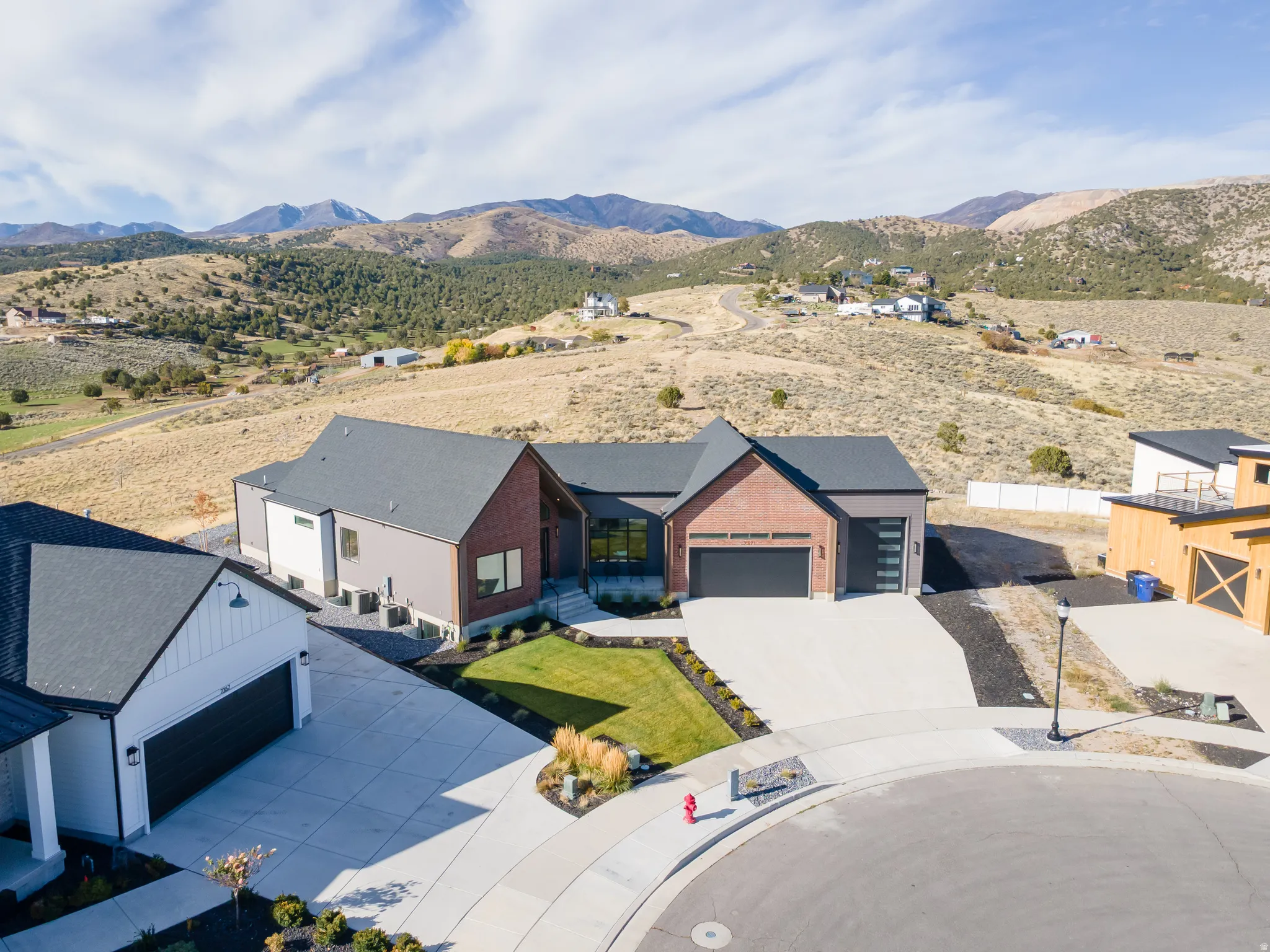 Modern exterior featuring brick and siding accents, a paved driveway, and an attached garage