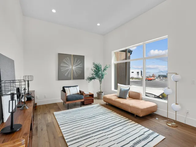 High ceilings with recessed lighting, large picture window, and wood-finish flooring