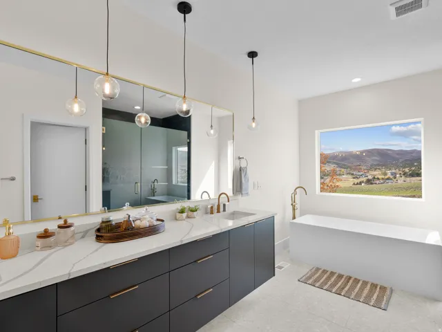Double vanity with a quartz countertop, rectangular undermount sinks, and brass-finish fixtures