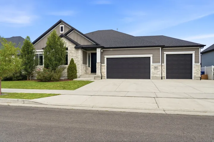 Stone and siding exterior with a dark shingled roof