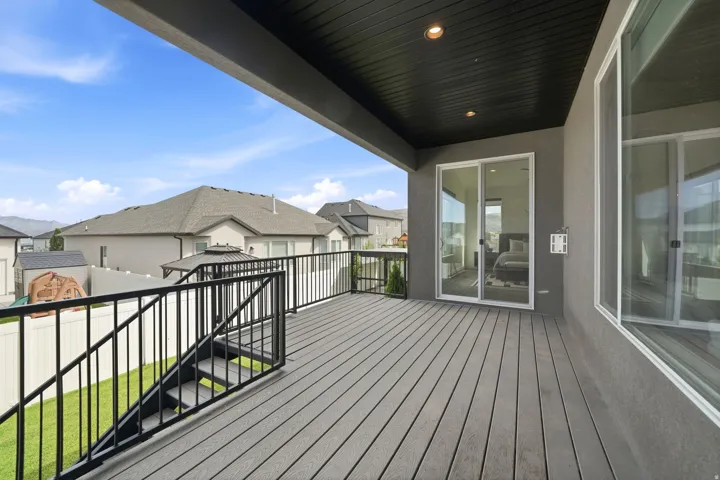 Expansive elevated deck with composite decking, black metal railings, and a built-in staircase