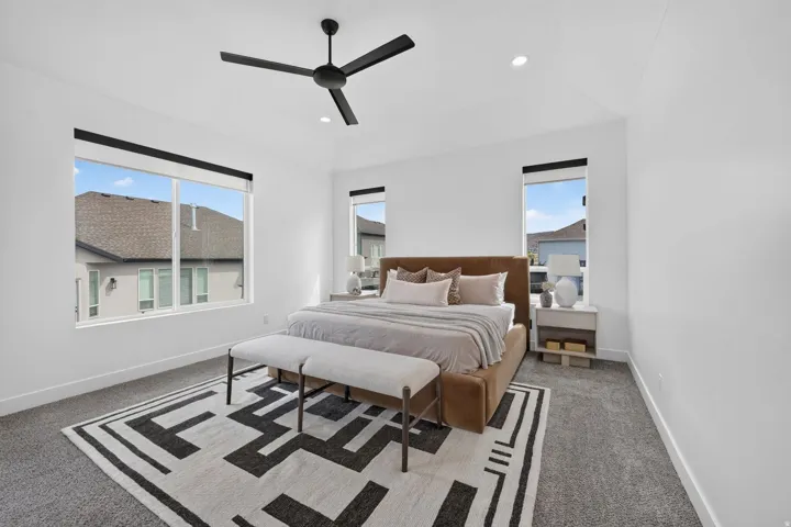 Vaulted ceiling with a black ceiling fan, recessed lighting, large windows, and gray carpeting