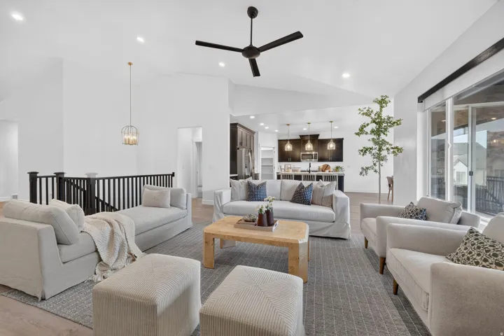 Vaulted ceilings with recessed lighting, exposed beam, wood-finish flooring, and a black spindle railing