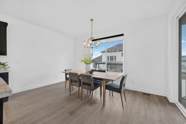 Recessed lighting, wood-finish flooring, large window, sliding glass door, and a modern ceiling fixture