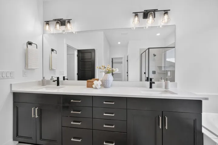 Dual vanity with a white countertop, undermount sinks, and matte black faucets