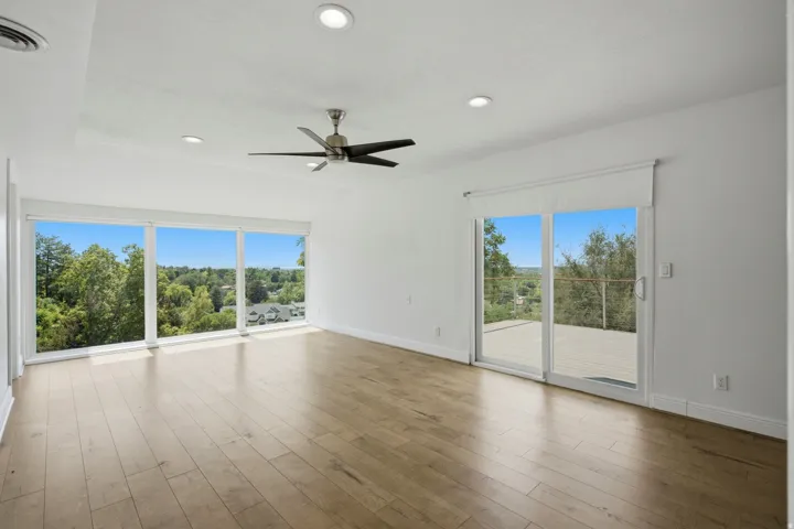 Expansive room featuring wood-finish flooring, recessed lighting, and a ceiling fan