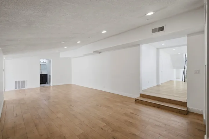 Open concept room featuring wood-finish flooring, recessed lighting, and a neutral color palette