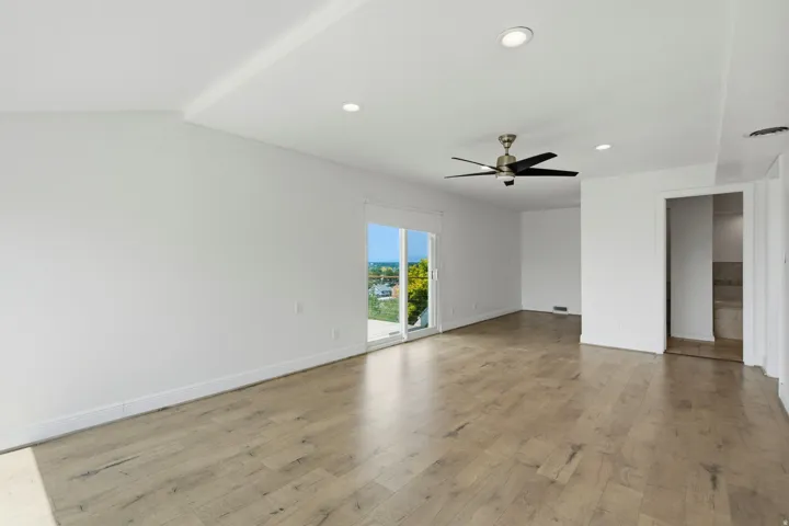 Open-concept room featuring wood-finish flooring, recessed lighting, a ceiling fan, and sliding glass doors