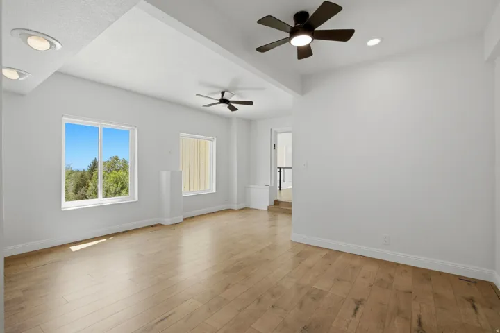 Wood-finish flooring, recessed lighting, and multiple ceiling fans