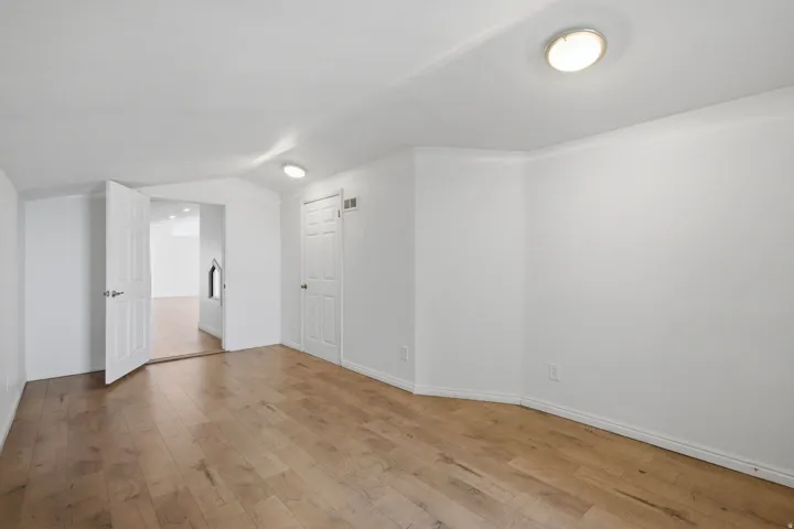 Wood-finish flooring, white walls, white trim, recessed lighting, and white interior doors