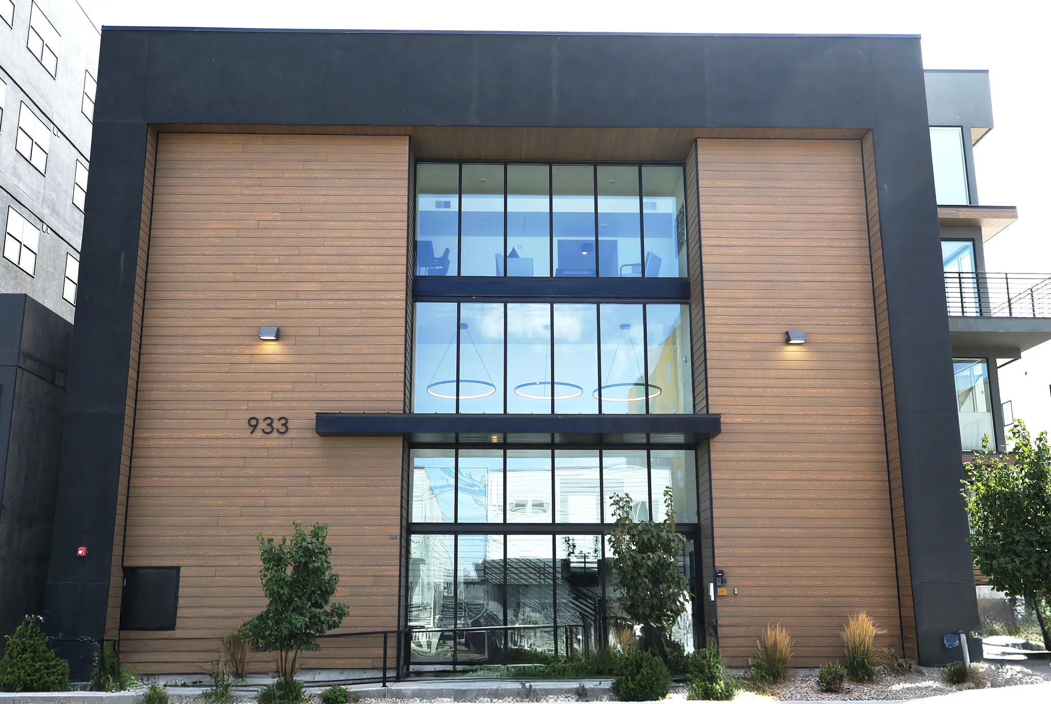 Modern exterior featuring wood-finish siding and expansive glass panels