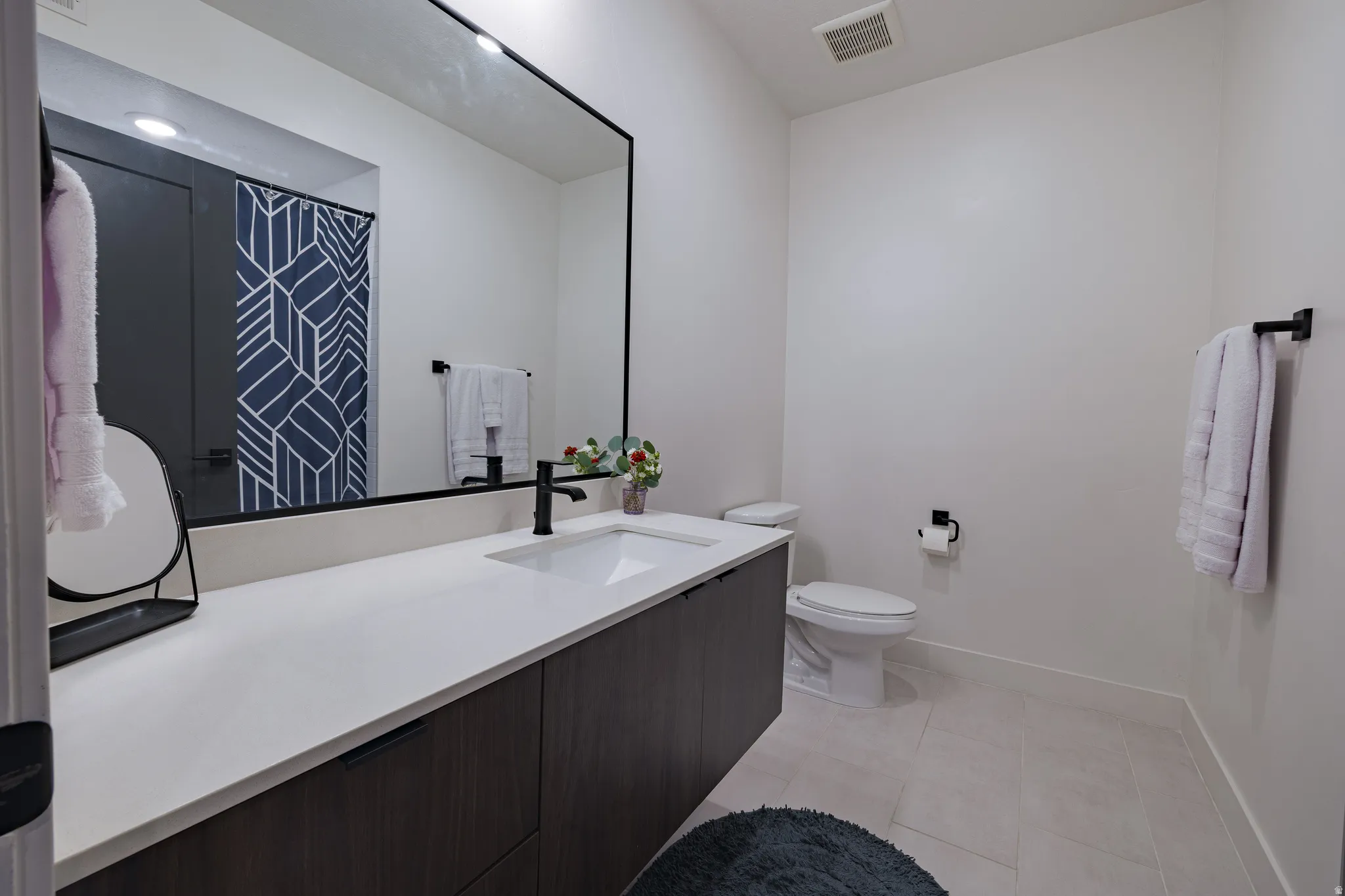 Spacious vanity with a white countertop and a single basin sink